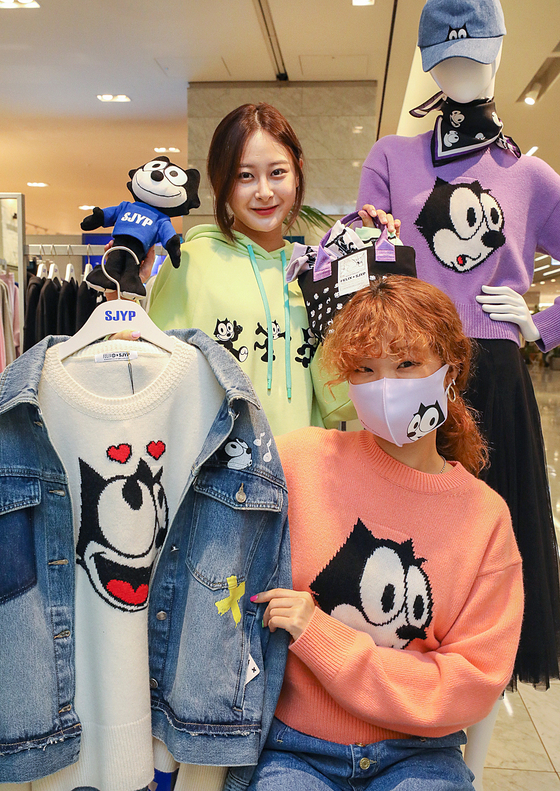 Models promote streetwear brand SJYP products featuring cartoon character Felix at Hyundai Department Store's Trade Center branch in southern Seoul on Thursday. The collection includes hoodies, sweaters, hats, masks and socks. [YONHAP]