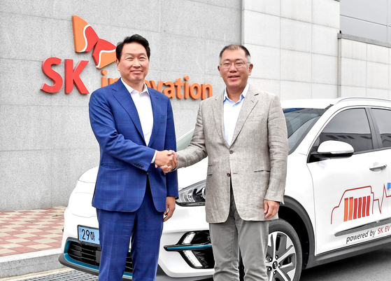 Hyundai Motor Group Executive Vice Chairman Euisung Chung, right, and SK Innovation Chairman Chey Tae-won shake hands on July 7 when Chung made a visit to SK Innovation's battery factory in Seosan, South Chungcheong. [HYUNDAI MOTOR]