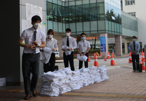 Residents at the Catholic University of Korea Seoul St. Mary’s Hospital in Seocho District, southern Seoul, take off their gowns and stage a walkout as young doctors since Friday kicked off a strike to protest the government’s plans to increase the medical school admissions quota. [NEWS1]