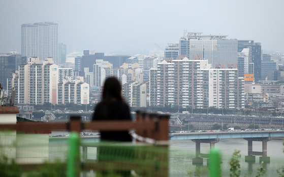A woman looks at apartments in an area south of the Han River on Wednesday. [YONHAP] 