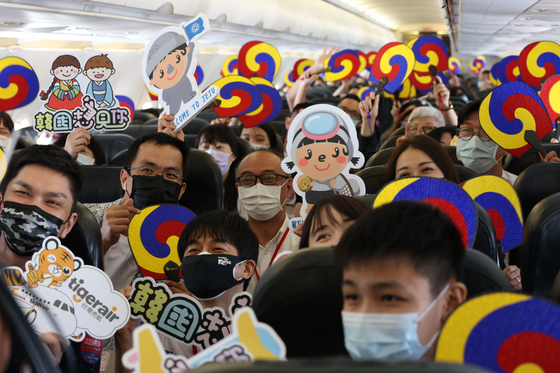 Taiwanese tourists ride a sightseeing flight to Jeju Island on Saturday. The Tigerair aircraft circled low around the island area and then returned to Taiwan without landing on the scenic island. [YONHAP]