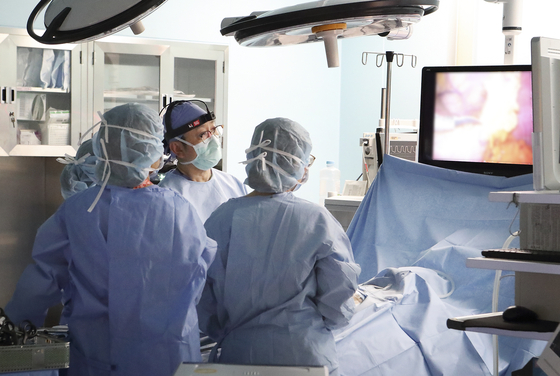 Doctors at Samsung Medical Center in Gangnam, southern Seoul, use KT’s 5G-powered ’Snyc Cam,“ which sends out high-definition video during surgery. [KT]