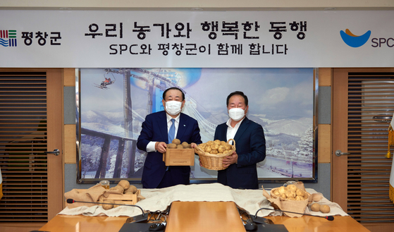 SPC group CEO Hwang Jae-bok and the Han Wang-ki, head of the Pyeongchang County Office, take a commemorative photo on Monday. [SPC GROUP]