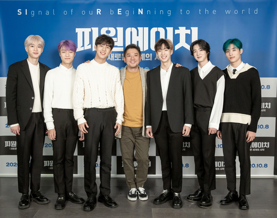 Chang Gamdok, center, poses with members of P1Harmony on Tuesday prior to the online press conference. The members of P1Harmony are, from left: Theo, Jongseob, Intak, Jiung, Soul and Keeho. [FNC ENTERTAINMENT]