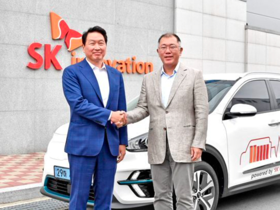SK Chairman Chey Tae-won, left, and Hyundai Motor Group Executive Vice Chairman Euisun Chung shake hands at SK Innovation's factory in Osan, South Chungcheong, in July. [HYUNDAI MOTOR]