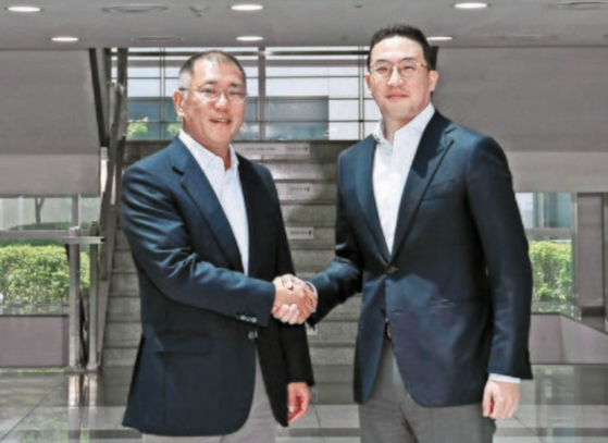 Hyundai Motor Group Executive Vice Chairman Euisun Chung, left, shakes hands with LG Chairman Koo Kwang-mo at LG Chem's factory in Ochang, North Chungcheong, in June. [HYUNDAI MOTOR]