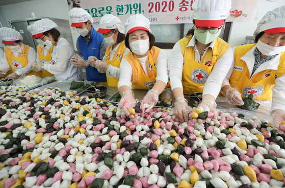 At the Nowon branch of the Korean Red Cross in Seoul on Wednesday, volunteer workers make songpyeon, or half moon-shaped stuffed rice cakes, which will be handed out to those in need for the coming Chuseok holiday, or Korean harvest festival. [NEWS1]