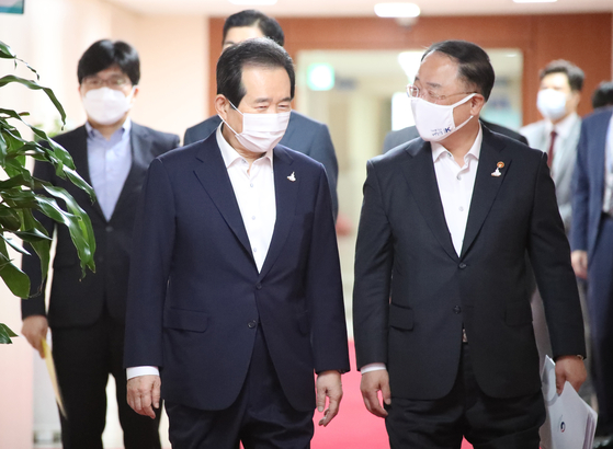 Prime Minister Chung Sye-kyun, left, and Finance Minister Hong Nam-ki walk into a cabinet meeting at the government complex in central Seoul on Wednesday. The National Assembly approved a 7.8 trillion won ($6.9 billion) fourth supplementary budget late Tuesday. [YONHAP]
