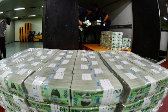 Workers from the note-issuing bureau of the Bank of Korea in Gangnam District, southern Seoul, on Thursday unload brand-new bank notes to be circulated in commercial banks for the coming Chuseok harvest holidays. [JOINT PRESS CORPS]