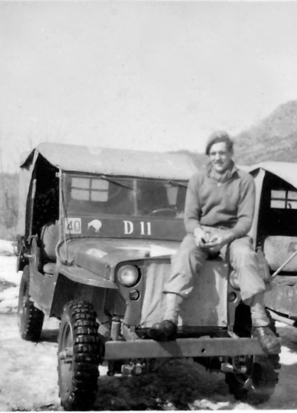 Des Vinten sitting on the bonnet of his jeep. "The 40 on the windscreen was the Tac Sign for 1 Britcom Divisional Signal Regiment, the Kiwi says I am a Kiwi dispatch rider and the vehicle number D11 tells every one I am a dispatch rider and should not be delayed when on the road," he said. [DES VINTEN]