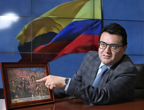 Pointing to a photo taken during the war by Colombian veteran Sergeant Major Gilberto Diaz Velasco, Ambassador of Colombia to Korea Juan Carlos Caiza speaks with the Korea JoongAng Daily on June 29 at the Embassy of Colombia in central Seoul. [PARK SANG-MOON]