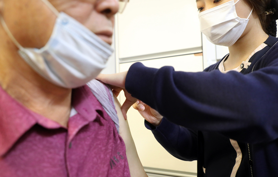 A patient receives a flu shot at a hospital in Dongdaemun District, eastern Seoul, on Sept. 28, which she will pay for. [YONHAP]