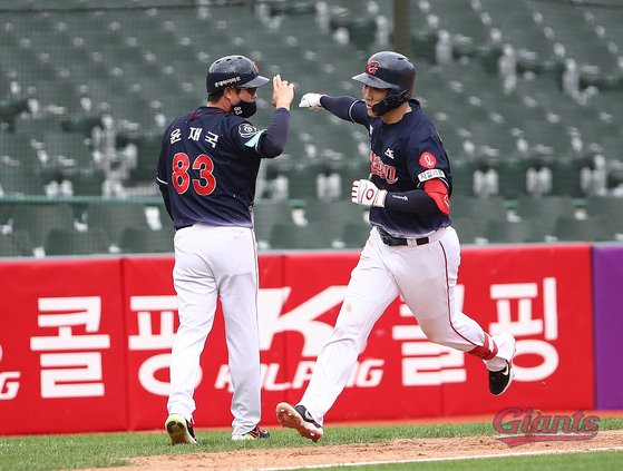 Lotte Giants infielder Oh Yoon-suk, right, celebrates after hitting a grand slam during a game against the Hanwha Eagles at Sajik Baseball Stadium in Busan on Sunday. [YONHAP] 