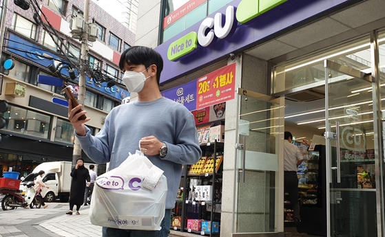 An on-foot delivery man uses his mobile navigation service to deliver items to a customer after picking them up at a CU convenience store. [BGF RETAIL]