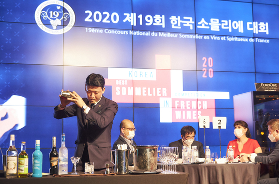 A bartender shakes up a cocktail on stage during the final round of the 19th Korea Best Sommelier in French Wines Competition held at the JW Marriott in Jongno District, central Seoul, on Tuesday. [SOPEXA KOREA]
