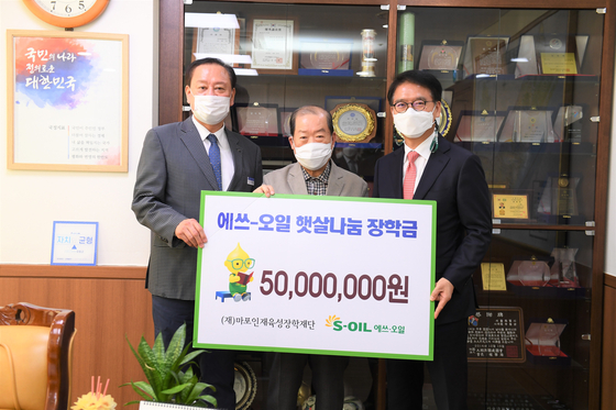 From right, S-Oil President Ryu Yul, Mapo Scholarship Foundation President Park Hong-seop and Mapo District Office head Yoo Dong-gyun pose after a ceremony held Thursday in Mapo District Office, western Seoul. The oil refiner donated 50 million won ($43,600) to the Mapo Scholarship Foundation for students from lower-income households. [S-OIL]
