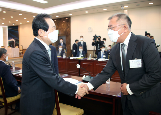 Prime Minister Chung Sye-kyun, left, greets Hyundai Motor Group Chairman Euisun Chung at the government complex in downtown Seoul before Thursday's hydrogen economy committee meeting. [YONHAP]