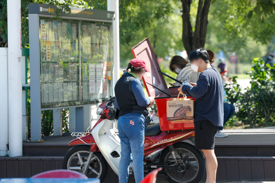 A delivery rider delivers food to a customer in Yeouido, western Seoul, in September. [NEWS1]