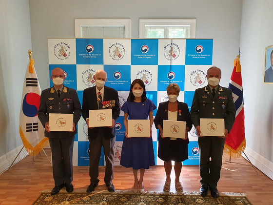 Nils Steen Egelien, president of the Norwegian Korean War Veterans Association, second from left, and Korean Ambassador to Norway Nam Young-sook pose during a ceremony to present the masks to Korean War veterans at the embassy in Oslo on June 15. [EMBASSY OF KOREA IN NORWAY]
