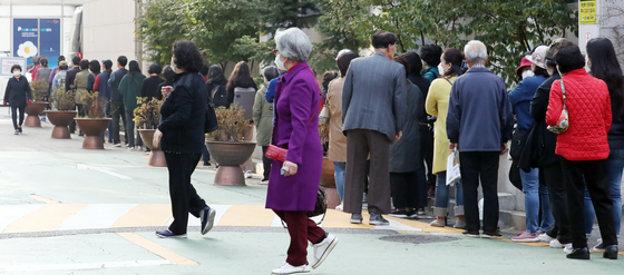 People stand in a line to get free flu shots in Gangseo District, western Seoul, on Monday. This week, the shots are being given to people over 70. From Oct. 26, people between the ages of 62 and 69 can get the shots. [NEWS1]