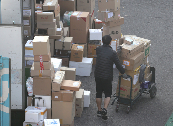 A delivery worker works at a distribution center in Seoul on Tuesday. [NEWS1]