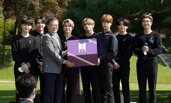 President Moon Jae-in receiving a present from boy band BTS on Sept. 19, after inviting the band to the first Youth Day ceremony held at the Blue House, central Seoul. [YONHAP]