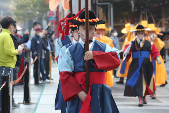 At the main gate of Deoksu Palace in central Seoul on Tuesday, actors resume the daily changing of the guard ceremony, which has been suspended since Feb. 1 because of the Covid-19 outbreak. [YONHAP]