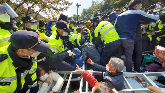Police officers try to disperse residents and civic activists holding a protest against the planned transport of equipment onto a Terminal High Altitude Area Defense (Thaad) battery site in Seongju, North Gyeongsang, on Thursday. The Defense Ministry said non-weapon materials and construction equipment were brought onto the base after police dispersed protesters. [YONHAP]