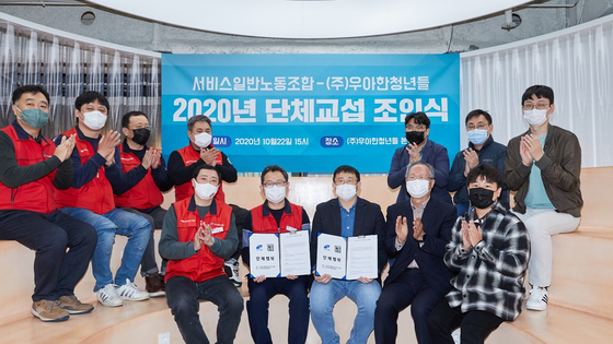 Woowahan Youths CEO Kim Byoung-woo, third from left in the front row, and representatives from the Korean Federation of Service Worker's Union pose for a photo after signing a collective bargaining agreement in Seocho District, southern Seoul on Thursday. [WOOWAHAN YOUTHS] 