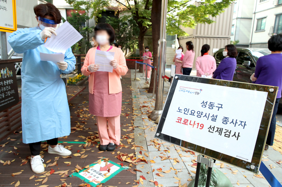 Staff members of nursing homes in Seongdong District, eastern Seoul, line up to be tested for Covid-19 on Friday. The district office has called on all staff members of nursing homes in the district to be tested regardless of if they have symptoms or not, as clusters of Covid-19 infections have recently been based in nursing homes. [NEWS1]