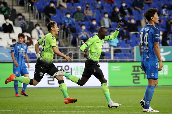 Jeonbuk Hyundai Motors players, in green, celebrate after Mo Barrow scored the opener during a match against Ulsan Hyundai FC at Munsu Football Stadium in Ulsan on Sunday. [NEWS1] 
