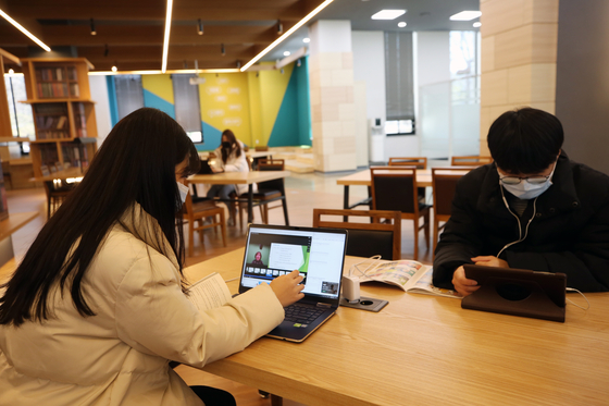 Gwangju University students attend online classes at a school library in Gwangju, South Jeolla on the first day of their school year in March. [YONHAP]
