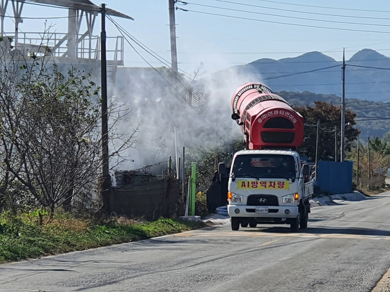A truck sprays disinfectant at farms in Cheonan, South Chungcheong, Sunday, following the detection of a highly pathogenic avian influenza virus. [YONHAP]  