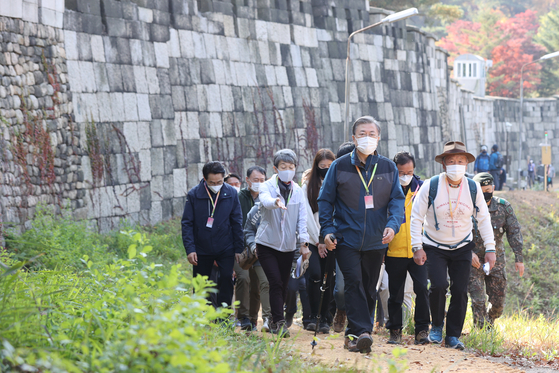 President Moon Jae-in, foreground, on Saturday goes trekking on Mount Bugak, just behind the presidential compound in Seoul, and unlocked the gate to the route 52 years after it was declared off-limits for security reasons. Renowned mountaineer Um Hong-gil, right, and Chung Jae-suk, left, head of the Cultural Heritage Administration, accompanied Moon on the trek. [YONHAP]