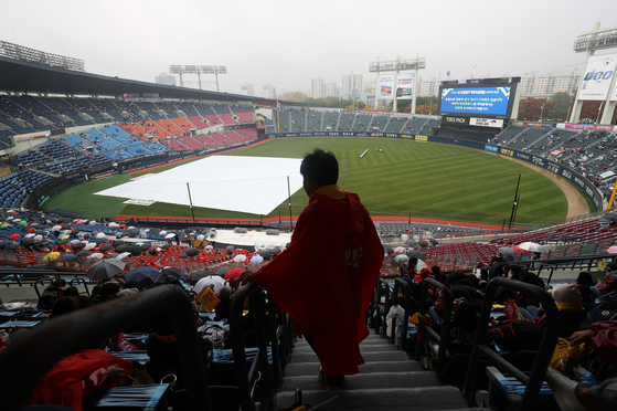 Fans wait for Game 1 of the Wildcard Series between the LG Twins and the Kiwoom Heroes to start amid pouring rain at Jamsil Baseball Stadium in southern Seoul on Nov. 1. The game was ultimately canceled and rescheduled for Monday at 6:30 p.m. [YONHAP]