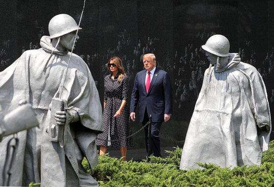 U.S. President Donald Trump and first lady Melania Trump walk past statues as they arrive for a wreath laying ceremony at the Korean War Veterans Memorial in Washington, D.C. on June 25. [REUTERS/YONHAP]
