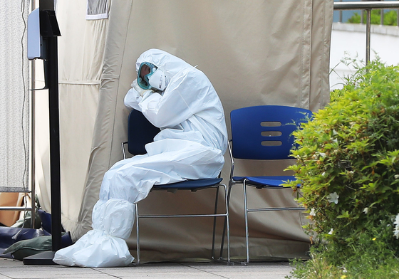 A medical staff member at a screening station takes a break outdoors in Jungnang District, eastern Seoul, May 12. [YONHAP]