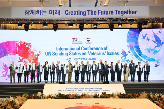 Envoys from 22 UN Sending States pose for a group photo on the stage after they adopt a joint communique that reaffirmed cooperative ties among the countries at an international conference on veterans’ issues held in Signiel Hotel in Busan on Tuesday, ahead of the Turn Toward Busan ceremony. [NEWS1]