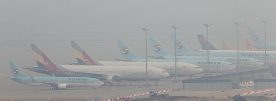 Korean Air Lines and Asiana Airlines carriers parked at the Incheon International Airport on Friday. [YONHAP]