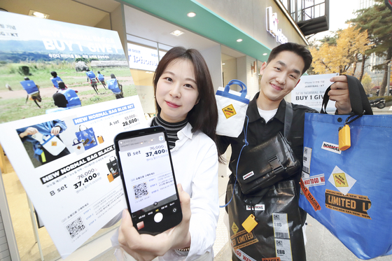 Models pose with New Normal Bags, which is a collaborative CSR project with social enterprise Jerrybag and a buy-one, give-one campaign for the release of the iPhone 12. [YONHAP]