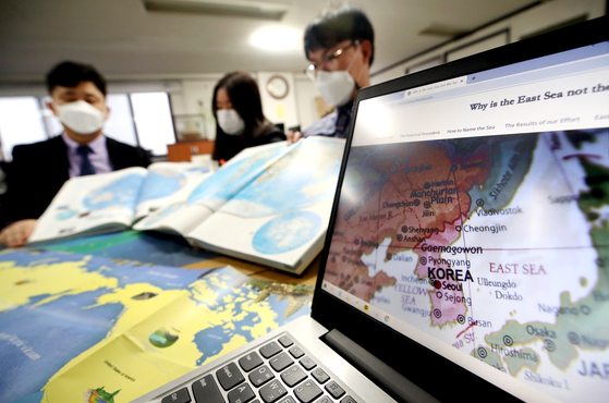 Members of the Voluntary Agency Network of Korea review maps of the East Sea in their office in Seongbuk District, northern Seoul, Tuesday as the International Hydrographic Organization (IHO) reached a consensus Monday to name global seas with numerical codes rather than specific names. Korea and Japan have struggled over the name the body of water between the two countries as Tokyo has called for the sole use of the Sea of Japan moniker. [YONHAP]