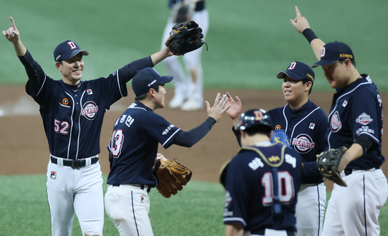 The Doosan Bears celebrate after picking up a 5-4 victory against the NC Dinos in Game 2 of the Korean Series at Gocheok Sky Dome in western Seoul on Wednesday. [YONHAP]