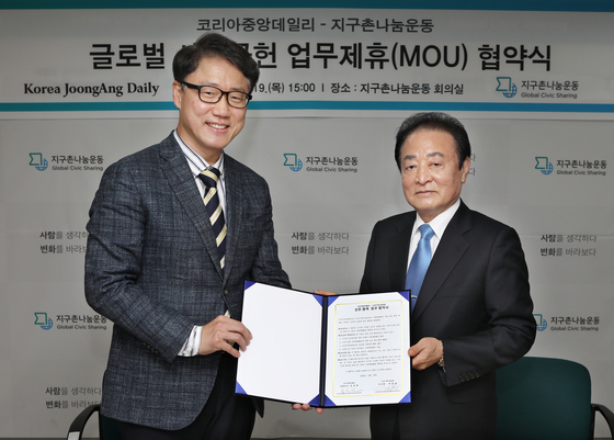 Ryu Kwon-ha, left, CEO of the Korea JoongAng Daily, and Park Myung-kwang, chairman of Global Civic Sharing, pose for a photo at the civic group’s office in central Seoul on Thursday after signing a memorandum of understanding to cooperate on overseas development projects, such as poverty eradication and sustainable development in developing countries. [PARK SANG-MOON]