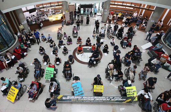 An alliance of 34 groups representing people with disabilities hold a press conference at the lobby of Hwaseong City Hall in Gyeonggi on July 10, 2020, and demand that the local government improve its welfare services to improve their daily activities.  [YONHAP] 