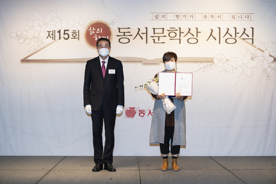 Dongsuh Foods CEO Lee Kwang-bok, left, poses with Kim Hye-young, winner of the grand prize at the 15th Scent of Life Dongsuh Literature Awards, in central Seoul on Wednesday. [DONGSUH FOODS]