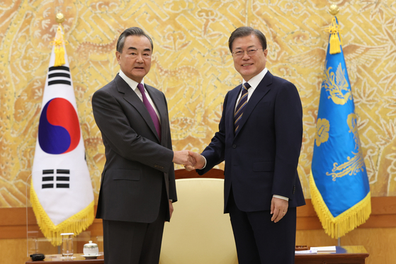 Korean President Moon Jae-in, right, shakes hands with Chinese State Councilor and Foreign Minister Wang Yi at the Blue House in central Seoul Thursday afternoon. [YONHAP]