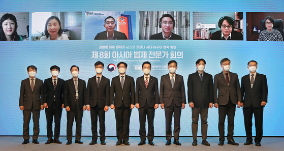 Attendees of the 8th Asian Legislative Experts Symposium at Millennium Hilton Seoul in Jung District, central Seoul, gather onstage Wednesday for a commemorative photo. From fifth from far left are Yeo Han-koo, presidential secretary for new southern and northern policy; Minister of Government Legislation Lee Kang-seop; and Kim Kye-hong, president of the Korea Legislation Research Institute. [PARK SANG-MOON]