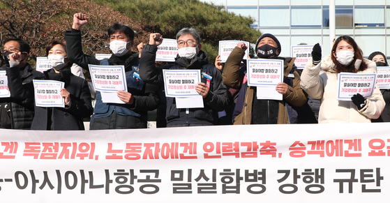 Asiana Airlines labor union members protest their company being acquired by Korean Air Lines in front of Korea Development Bank in Yeouido, western Seoul, on Thursday. [YONHAP]