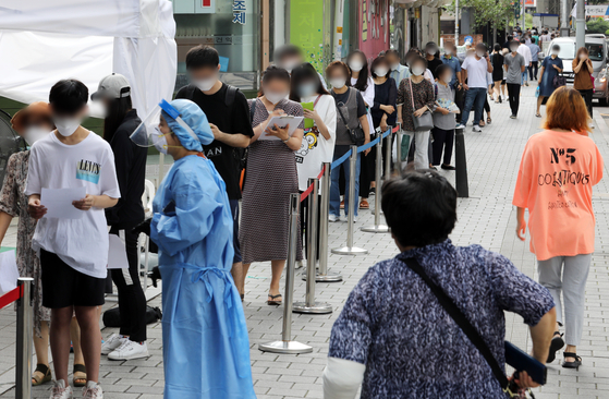 People wait to get tested at a Covid-19 testing site in Seongbuk District, central Seoul, Monday, amid a growing cluster from a church nearby. [NEWS1]