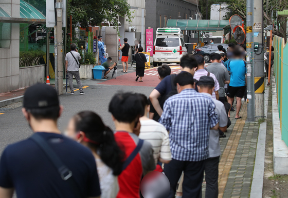 People line up at a Covid-19 testing site in Guro District, western Seoul, Thursday, where eight people from the same apartment building tested positive for the virus. [YONHAP]